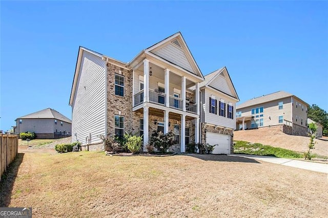 view of front of home with a front lawn, a balcony, and a garage