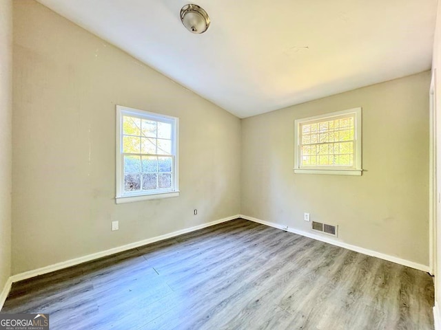 unfurnished room with wood-type flooring and vaulted ceiling