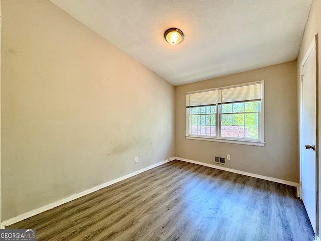 spare room with dark wood-type flooring