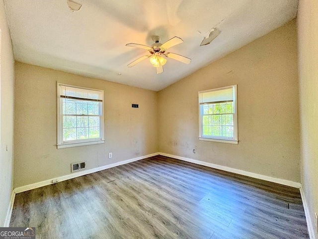 unfurnished room featuring wood-type flooring, a healthy amount of sunlight, lofted ceiling, and ceiling fan