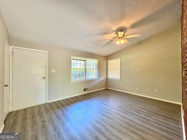 unfurnished room with lofted ceiling, hardwood / wood-style floors, a textured ceiling, and ceiling fan