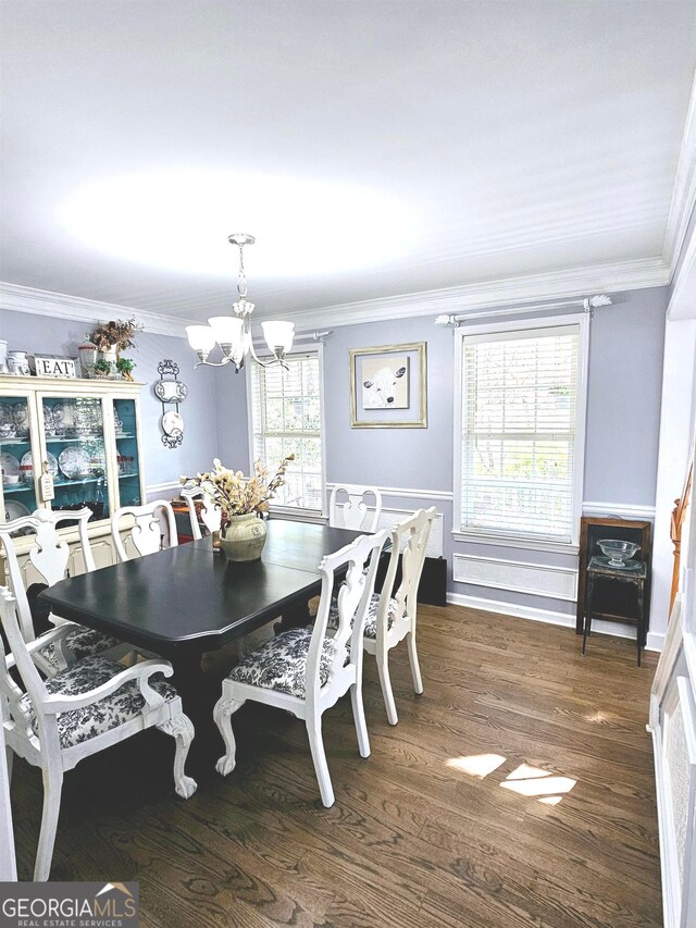 dining space with a healthy amount of sunlight, ornamental molding, dark hardwood / wood-style floors, and a chandelier