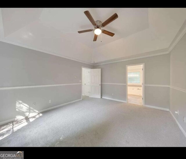 carpeted spare room featuring ceiling fan and crown molding