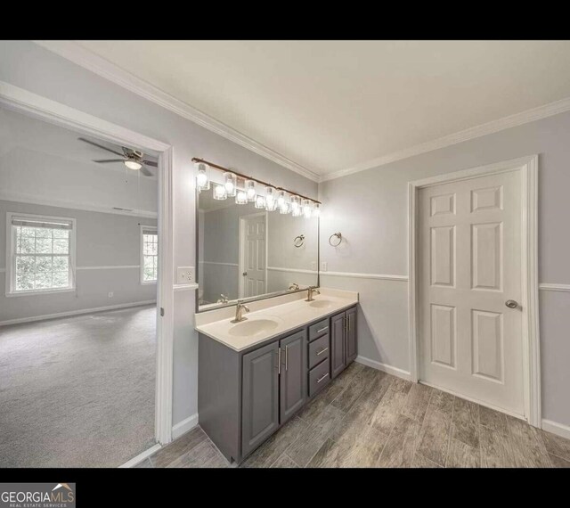 bathroom with ceiling fan, vanity, crown molding, and hardwood / wood-style flooring