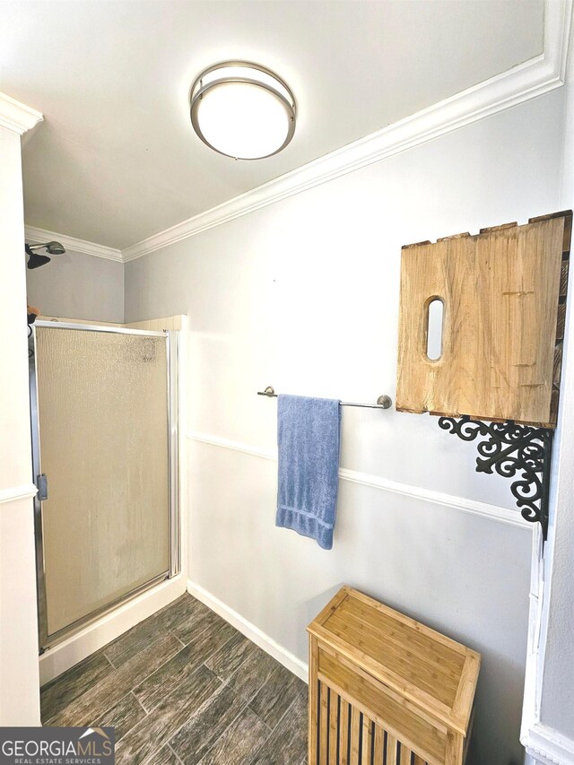 bathroom with ornamental molding, wood-type flooring, and a shower with door