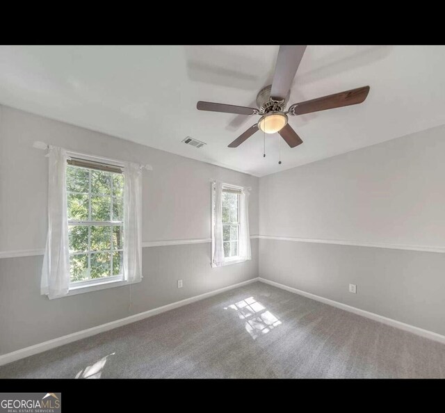 carpeted spare room with ceiling fan