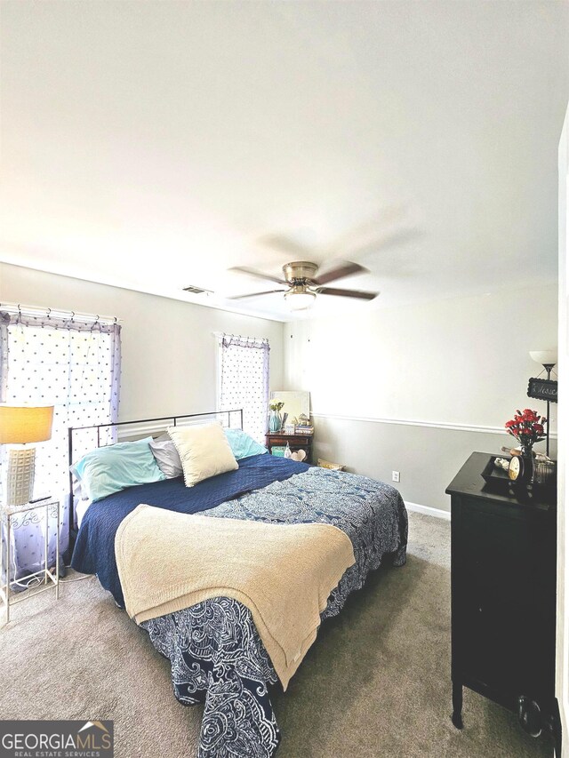 bedroom featuring ceiling fan and dark colored carpet