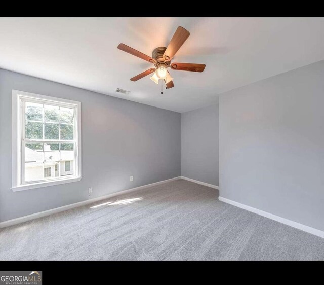 carpeted empty room featuring ceiling fan