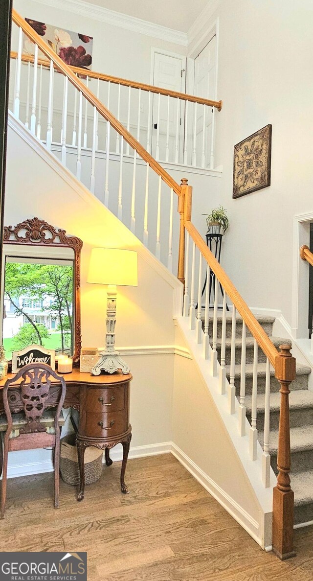 stairway featuring crown molding and hardwood / wood-style flooring