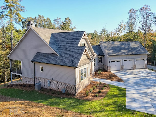 view of front of home with central AC unit, a front yard, and a garage