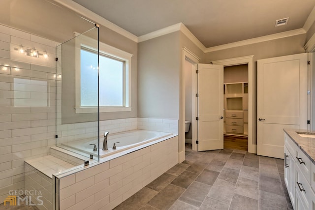 full bathroom featuring tile flooring, ornamental molding, plus walk in shower, and vanity