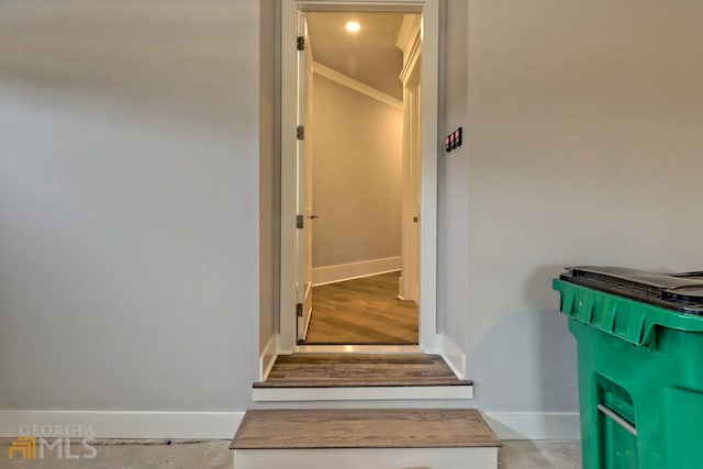 stairs with crown molding and light hardwood / wood-style floors