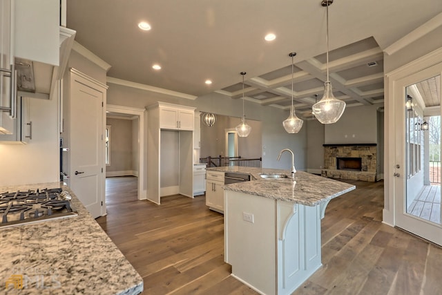 kitchen with dark hardwood / wood-style flooring, coffered ceiling, an island with sink, and white cabinets