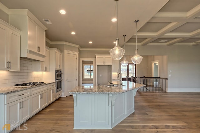 kitchen with beam ceiling, coffered ceiling, decorative light fixtures, white cabinetry, and light hardwood / wood-style flooring