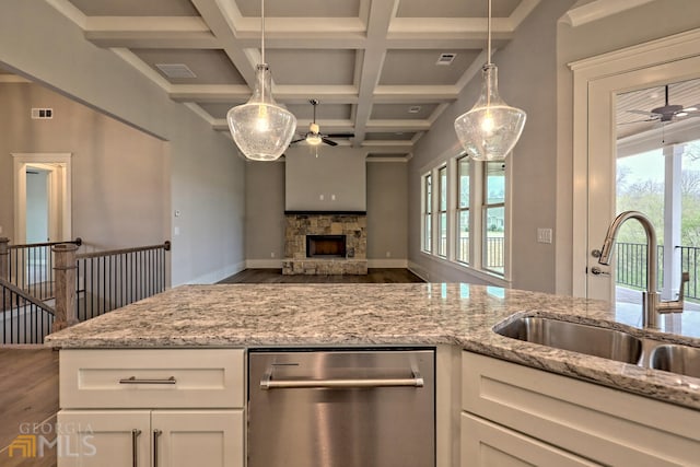 kitchen with ceiling fan, beam ceiling, coffered ceiling, a fireplace, and dishwasher