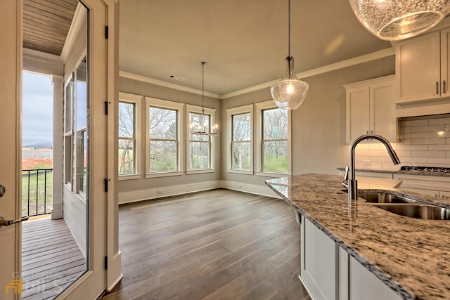 kitchen featuring decorative light fixtures, light stone counters, tasteful backsplash, white cabinetry, and dark hardwood / wood-style floors