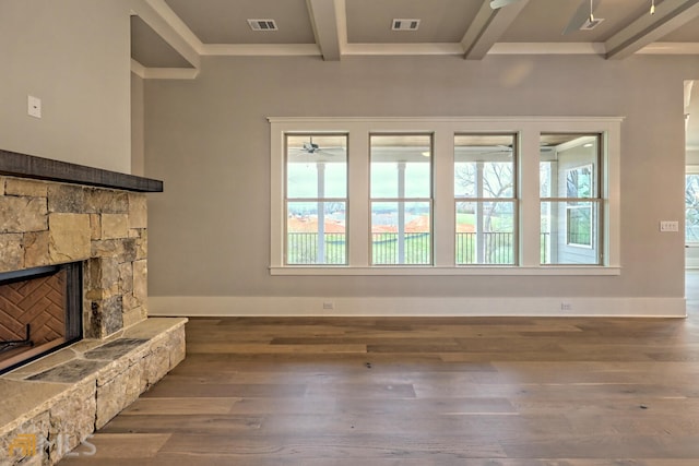 living room with ceiling fan, a stone fireplace, dark hardwood / wood-style floors, and beamed ceiling