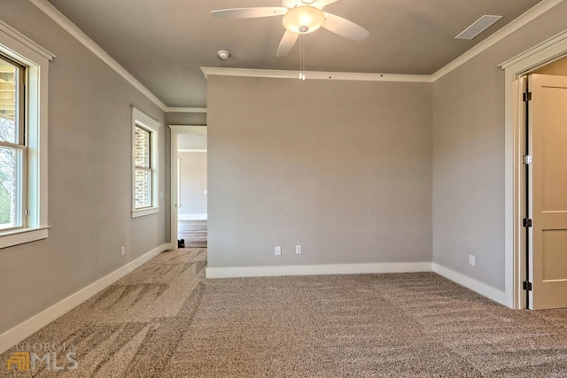 empty room with crown molding, ceiling fan, light colored carpet, and a healthy amount of sunlight