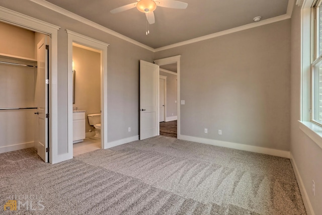 unfurnished bedroom with ceiling fan, crown molding, a closet, and light carpet