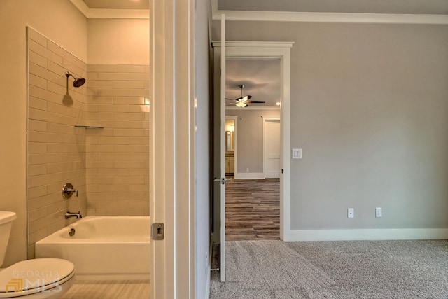 bathroom featuring tiled shower / bath combo, ceiling fan, toilet, and hardwood / wood-style floors