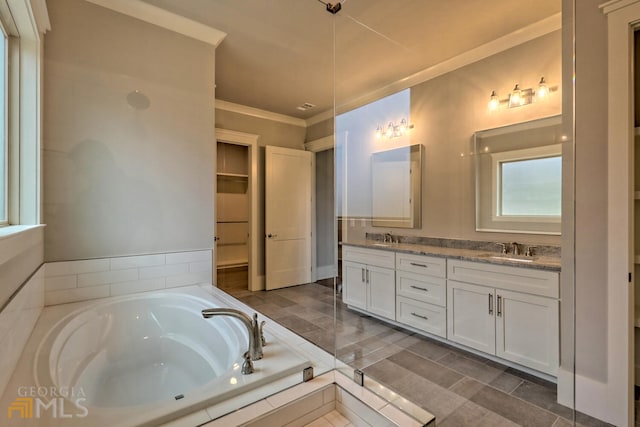 bathroom featuring tile floors, tiled bath, dual sinks, vanity with extensive cabinet space, and crown molding