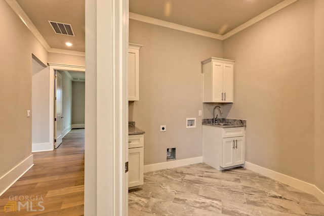 clothes washing area with light hardwood / wood-style flooring, crown molding, cabinets, and hookup for an electric dryer