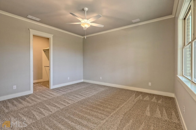 carpeted spare room with ceiling fan and ornamental molding