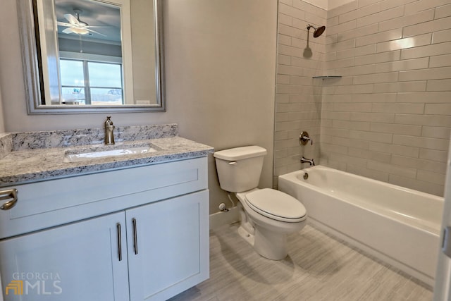 full bathroom featuring tiled shower / bath combo, ceiling fan, toilet, and vanity