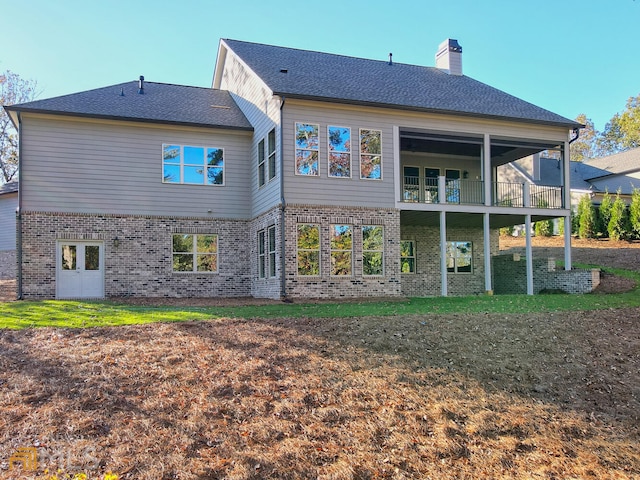 rear view of property featuring a lawn