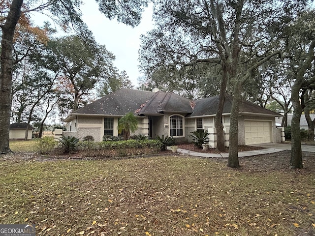 ranch-style house with a garage and a front lawn