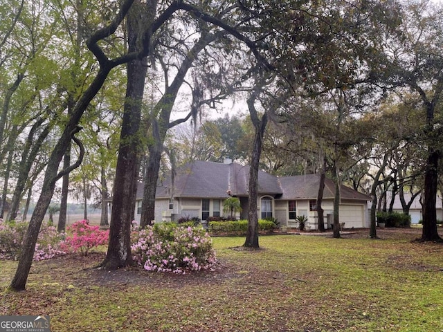 ranch-style house featuring a garage and a front yard