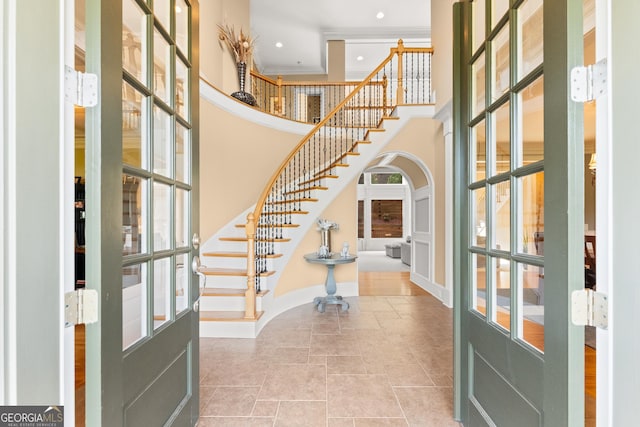 entryway featuring french doors and a towering ceiling