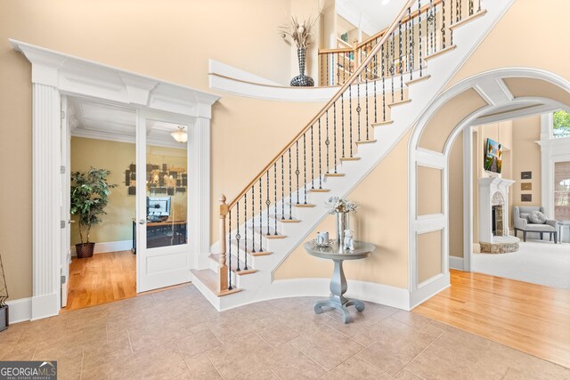 staircase with wood-type flooring and ornamental molding