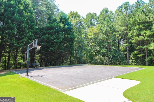 view of sport court with a lawn