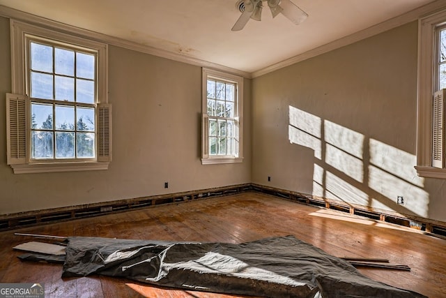 unfurnished room with hardwood / wood-style flooring, a healthy amount of sunlight, ceiling fan, and crown molding