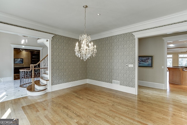 unfurnished dining area featuring a chandelier, light hardwood / wood-style floors, and ornamental molding