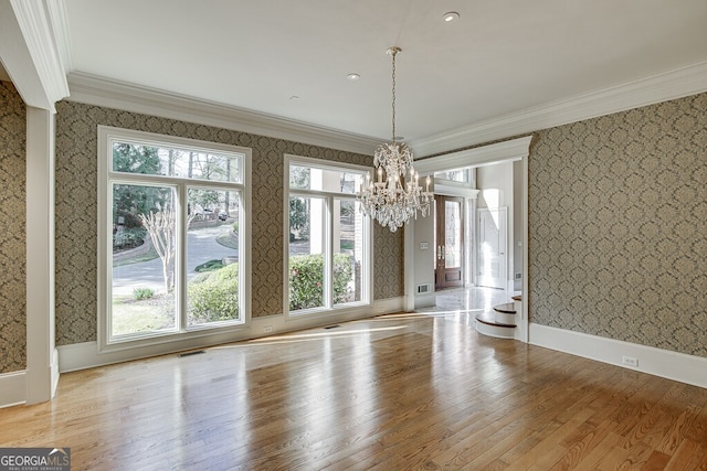 unfurnished room featuring light hardwood / wood-style floors, a chandelier, and a wealth of natural light