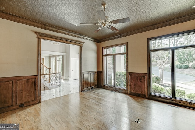 empty room featuring light hardwood / wood-style flooring, ceiling fan, and ornamental molding