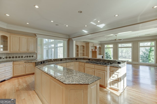 kitchen featuring light hardwood / wood-style floors, a center island, crown molding, and ceiling fan