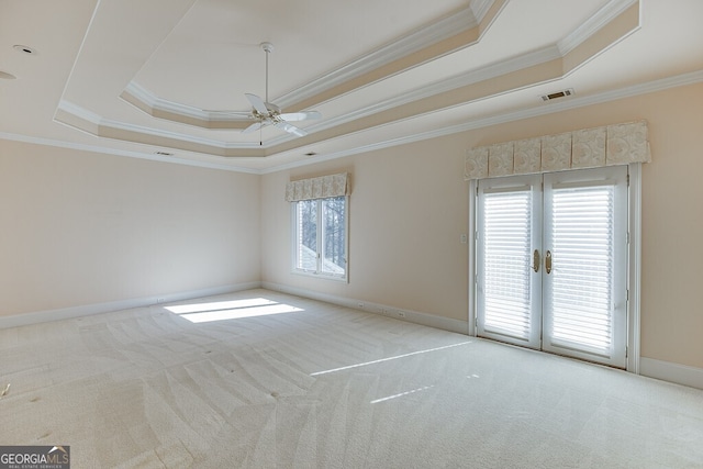 unfurnished room with french doors, a tray ceiling, and a wealth of natural light