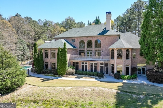 view of front of house featuring a balcony and a front yard