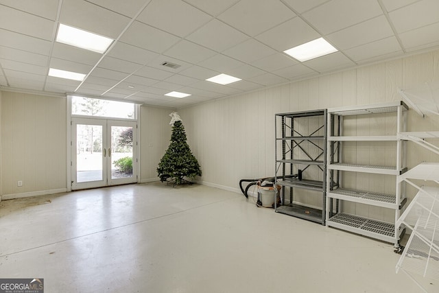 basement with french doors and a drop ceiling