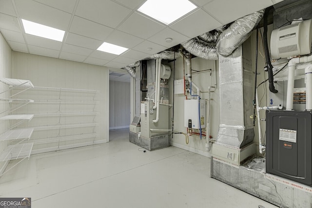 basement with heating utilities, water heater, and a drop ceiling