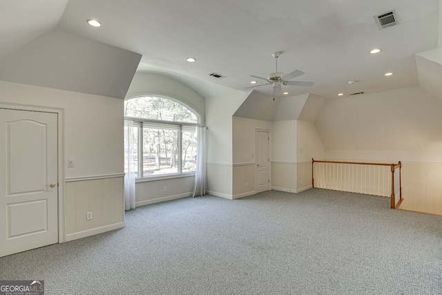 additional living space with vaulted ceiling, light colored carpet, and ceiling fan