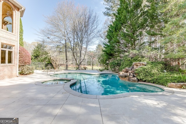 view of pool featuring a patio and an in ground hot tub