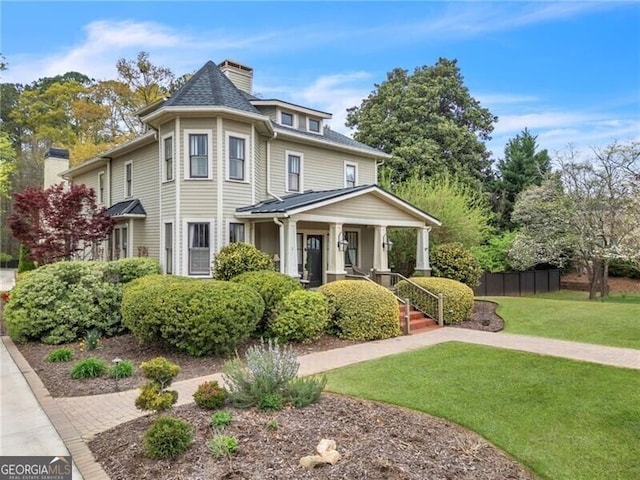 victorian house featuring a porch and a front lawn