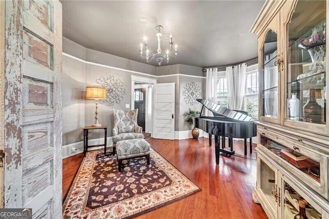 sitting room with dark hardwood / wood-style flooring and a chandelier