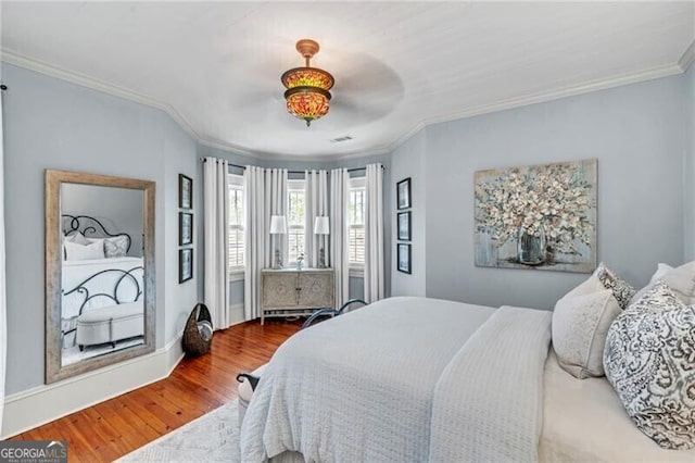 bedroom with ornamental molding, light hardwood / wood-style floors, and ceiling fan