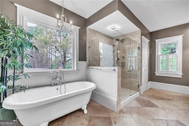 bathroom with an inviting chandelier, tile floors, and plus walk in shower