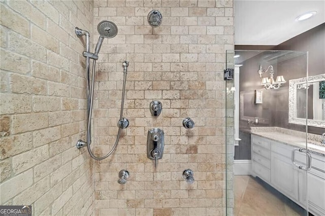 bathroom with tile flooring, a tile shower, and large vanity